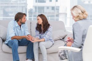 Therapist taking motes while couple is talking