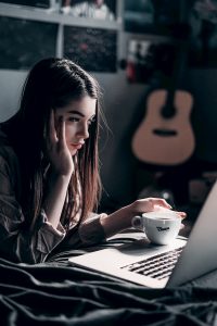 Bored young woman looking at her laptop. Maintaining your mental health while working from home